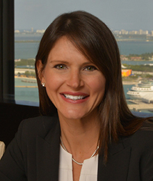 Deborah Baker Egozi Deborah Baker Egozi headshot, Caucasian female with brown hair, wearing a white shirt under a black blazer, pictured in front of a window that overlooks a lake